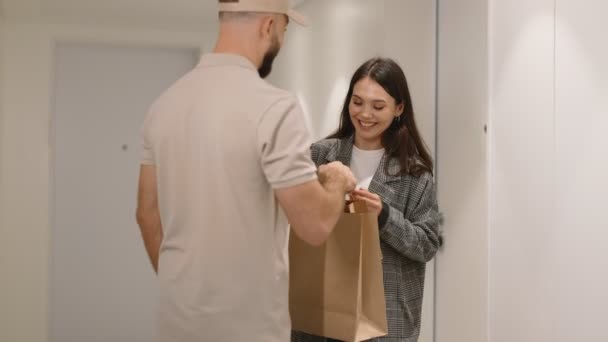 Веселая Молодая Женщина Принимает Заказ Бумажном Пакете Курьера Мужчины Себя — стоковое видео