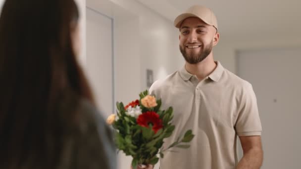 Uśmiechnięty Dostawca Czapce Zapewniający Radosną Kobietę Świeżymi Kwiatami Czerwonym Pudełkiem — Wideo stockowe