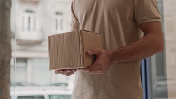 运送人手拿着一个小的 没有品牌的纸板箱 描述送货服务和网上购物的情况 — 图库视频影像