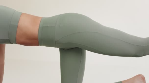 アライメントと姿勢に焦点を当てたヨガポーズを保持しているアクティブウェアの身元不明の女性のクローズアップ側のビュー — ストック動画