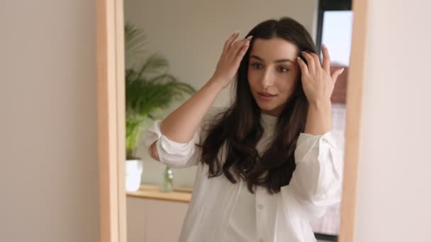 Seorang Wanita Menawan Dengan Ekspresi Konten Terlihat Cermin Menyentuh Rambutnya — Stok Video