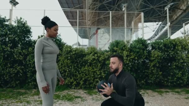 Vältränad Manlig Tränare Visar Squat Form Med Medicinboll Till Fokuserad — Stockvideo