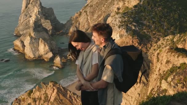 一对深情的夫妇享受着浪漫的落日的拥抱 俯瞰着美丽的海滨悬崖和大海 表达着彼此的爱意和融合 — 图库视频影像