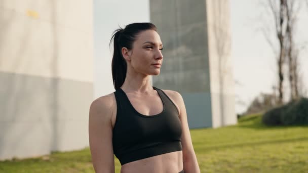 Sportiv Ung Kvinna Svarta Aktivitetskläder Visar Förtroende Samtidigt Poserar Utomhus — Stockvideo