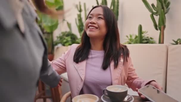 Radosne Różnorodne Przyjaciółki Dzielą Uścisk Podczas Szczerego Spotkania Kawiarni Świeżym — Wideo stockowe