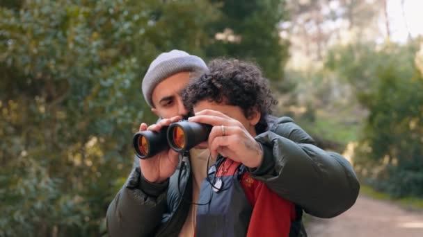 一位父亲和他的小儿子在森林里散步时 用双筒望远镜在一起探索并粘合在一起 — 图库视频影像