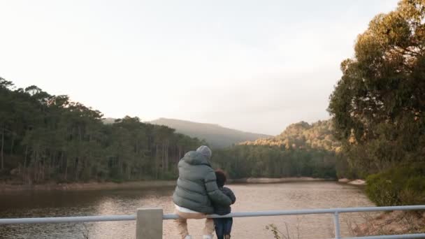 Вид Ззаду Батька Куртці Маленького Сина Мовчки Відображається Озеро Оточене — стокове відео