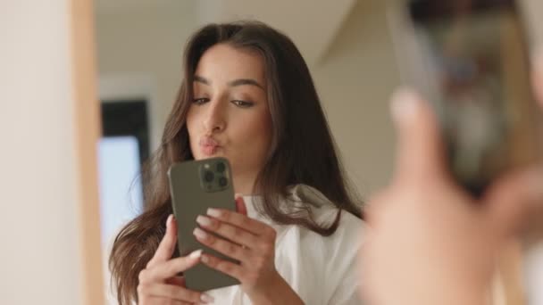 一个快乐的年轻女人用她的智能手机捕捉到了一个她在镜子里反射出来的自私自利者 — 图库视频影像