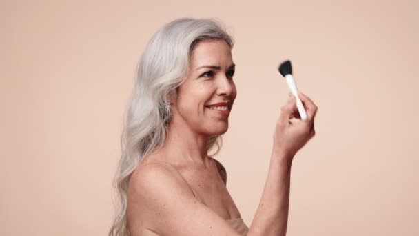 Mujer Madura Sonriente Con Pelo Gris Sosteniendo Cepillo Maquillaje Irradiando — Vídeos de Stock