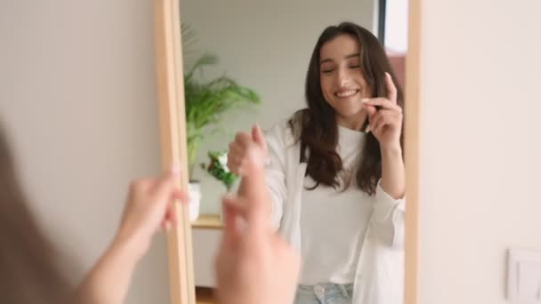カジュアルな服を着た陽気な若い女性は 鏡を見ながら喜んで踊り 自宅でポジティブさと自信を放つ — ストック動画