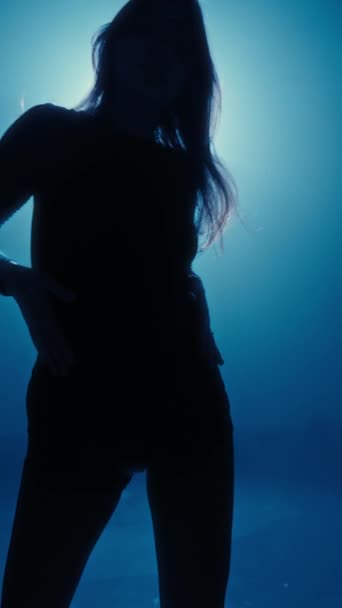 Tajemnicza Sylwetka Tańczącej Kobiety Podkreślona Nastrojowym Niebieskim Podświetleniem Ukazująca Elegancję — Wideo stockowe