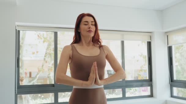 Spokojna Rudowłosa Kobieta Odzieży Sportowej Robi Pozy Namaste Podczas Treningu — Wideo stockowe