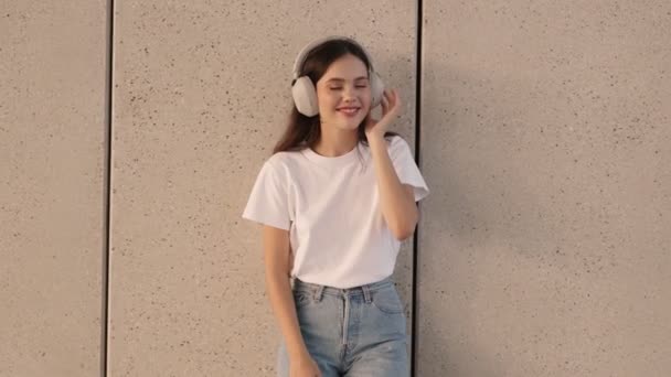 Cheerful Teenage Girl Listening Music Ear Headphones Leaning Concrete Wall — Stock Video