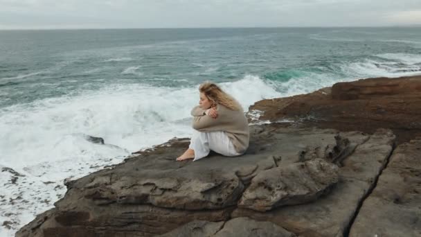 Une Femme Réfléchie Assise Seule Sur Une Plage Rocheuse Regardant — Video