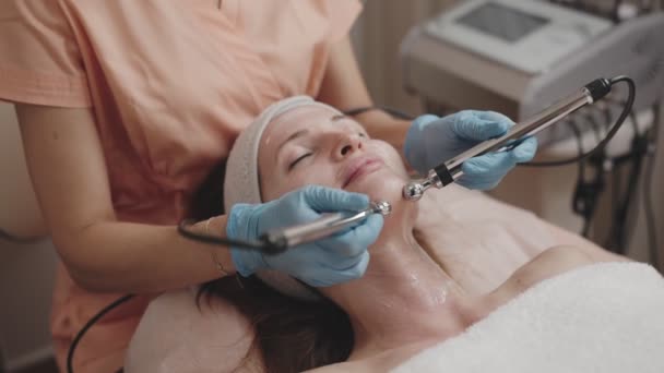 Esteticista Realiza Tratamiento Facial Microactual Cliente Femenino Relajado Entorno Spa — Vídeo de stock