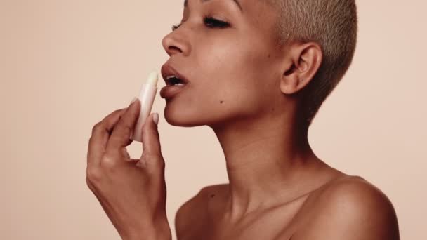 Confident African American Woman Short Hairstyle Applies Lip Balm Self — Stock Video