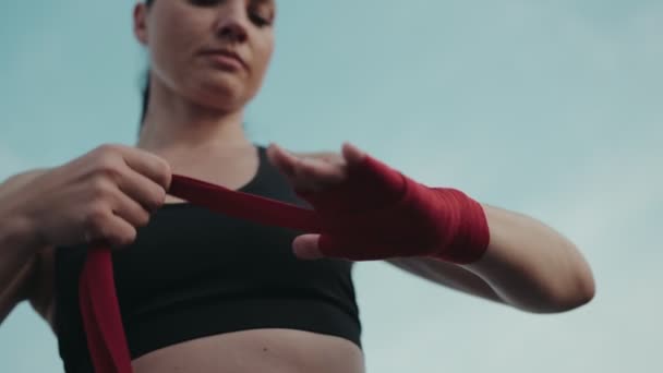 Определенная Женщина Готовится Боксу Заворачивая Руки Красными Защитными Обертками Изображая — стоковое видео