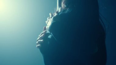 Puslu, sisli bir ortamda, şehvetli bir dans yapan bir kadının görüntüsü. Gizem ve zarafet saçıyor..