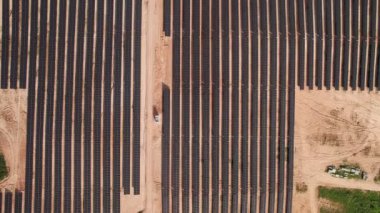 Hava perspektifinden yakalanan ve alternatif enerji kaynakları ve sürdürülebilirliği sembolize eden güneş enerjisi panellerinin minimalist sıraları.