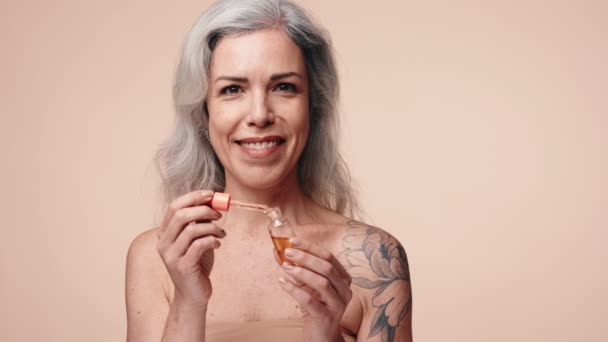 Una Atractiva Mujer Mayor Con Tatuaje Usando Gotero Para Aplicar — Vídeo de stock