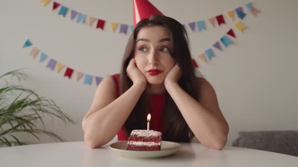 バースデーケーキを持って一人で座り 自宅で誕生日に悲しみを感じ 周囲に友達がいない思慮深い女性 — ストック動画