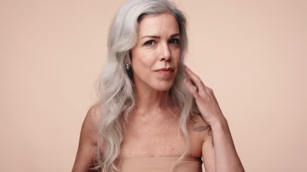 一位自信的中年妇女 灰白的头发修整着她的发型 描绘了一个自我照顾和美的概念 — 图库视频影像