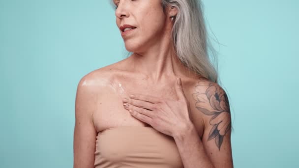 Elegancka Seniorka Tatuażem Nakłada Krem Nawilżający Szyję Klatkę Piersiową Symbolizujący — Wideo stockowe