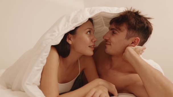 一对看不见的夫妇共享着温柔的拥抱 藏在舒适的毛毯下 传达着亲密和爱的感觉 — 图库视频影像