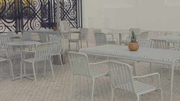 现代户外咖啡馆 配有空的金属椅子和桌子 以及放在鹅卵石路面上的盆栽中心 — 图库视频影像