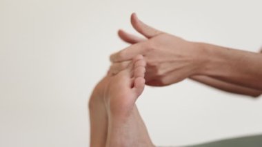 Yoga pratisyeninin parmak uçlarına dokunarak esnek ve dengeli olduğunu gösteren yakın plan bir görüntüsü..
