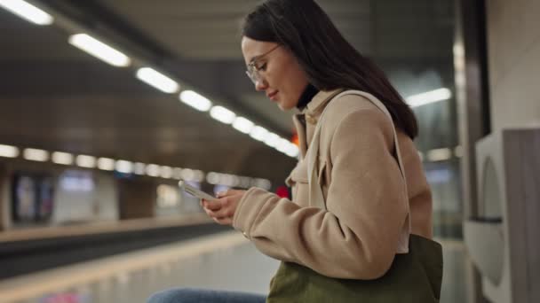 Молода Жінка Захоплена Своєму Смартфоні Станції Метро Чекаючи Вхідний Поїзд — стокове відео