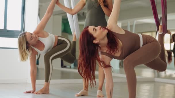 Seorang Instruktur Membantu Perempuan Melakukan Pose Yoga Terbang Menggunakan Hammocks — Stok Video