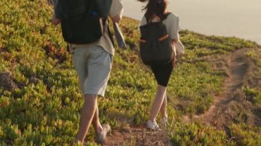 Sırt çantalı bir adam ve bir kadın güneşli bir yaz gününde yemyeşil dar bir patikada sakin bir yürüyüş yaparak macera ve sükunetin özünü yakalıyorlar..