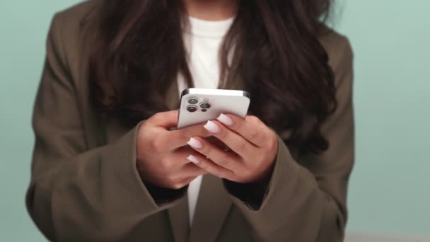 一个拿着智能手机的女人的特写 带着模糊的微笑专注于她的双手 传达着连接和现代生活方式 — 图库视频影像