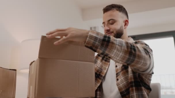 Muž Rozbaluje Doručovací Rozkaz Doma Odhaluje Obsah Lepenkové Krabice Mezi — Stock video