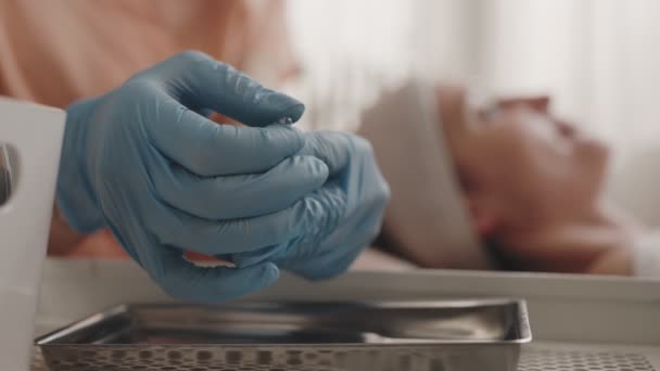 美容师手戴着蓝色手套 打开玻璃安瓿进行护肤治疗 — 图库视频影像