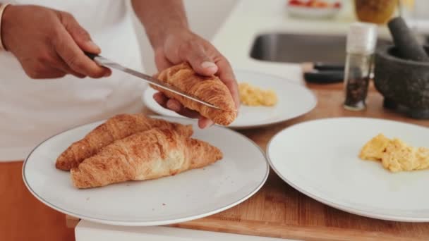 Close Hands Cutting Golden Brown Croissant Half Scrambled Eggs Background — Stock Video