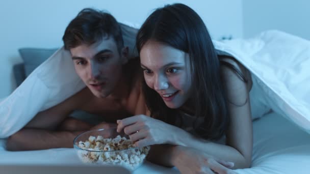 Een Jong Stel Gezellig Onder Een Deken Bed Popcorn Delen — Stockvideo