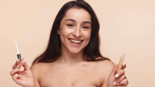 Ευτυχισμένη Νεαρή Γυναίκα Κρατώντας Σωλήνες Lip Balm Μια Χαρούμενη Έκφραση — Αρχείο Βίντεο