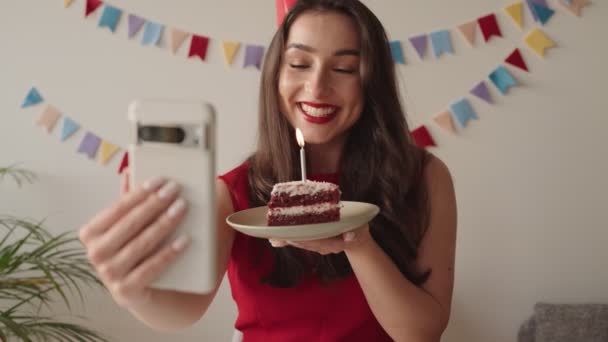 女人在和心爱的人进行电视交谈时 一边举着蛋糕一边庆祝自己的独身生日 — 图库视频影像
