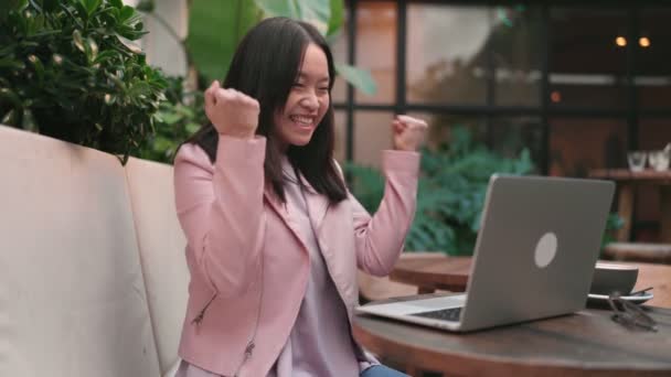 Екстатична Молода Азіатка Тріумфально Відзначає Свій Успіх Працюючи Ноутбуці Відкритому — стокове відео
