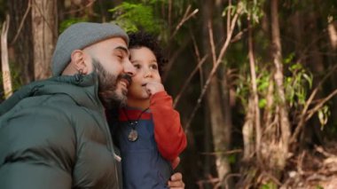 Bir adam merak uyandıran kıvırcık saçlı oğluna orman detaylarına dikkat çeker, doğaya ve eğitime olan sevgisini arttırır..