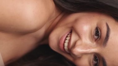 Detaylı bir yakın plan çekimde gülümseyen bir kadın yüzü, temiz cildini ve doğal güzellik ve cilt bakımını vurgular..