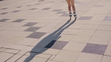 Güneşli bir günde asfalt zeminde paten kayan biri. Açık hava aktiviteleri, özgürlük ve aktif yaşam tarzı kavramı.