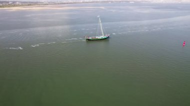 Sakin sularda süzülen tek bir yelkenlinin sakin hava görüntüsü huzur ve sükuneti simgeliyor..