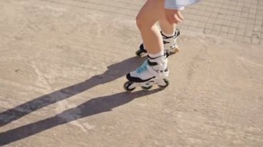 Güneşli bir günde paten kayan bir insanın yakın çekim görüntüsü, açık havada paten kaymanın hareketini ve etkinliğini vurguluyor..