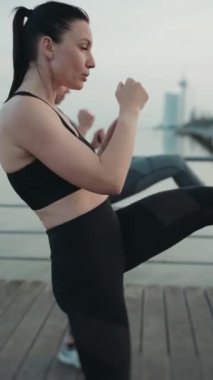 İki kadının dikey pozisyonu, dışa vuruşları, dayanıklılıklarını, sağlıklarını ve eşliklerini gösteriyorlar..