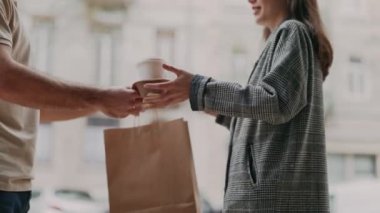 Dışarıdaki dost bir kuryeden sıcak kahve ve yiyecek getiren genç bir kadın..