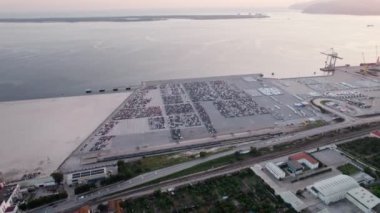 Park halindeki arabalarla dolu geniş bir liman altyapısını yakalayan bir hava görüntüsü, küresel ticaret ve ihracata hazırlık durumunu vurguluyor.