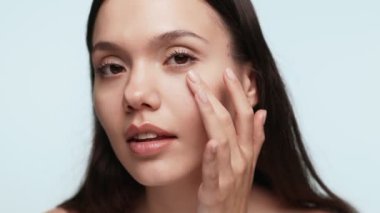 Makyajını dikkatlice yapan genç bir kadının yakın çekim görüntüsü, akşam yemeği için hazırlıkları öneriyor..